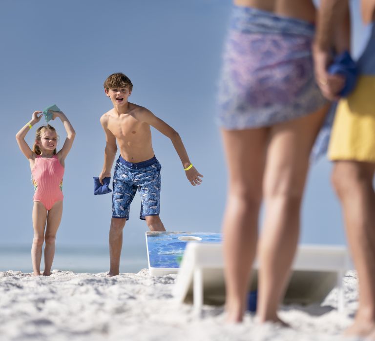 A Group Of People On A Beach Posing For The Camera