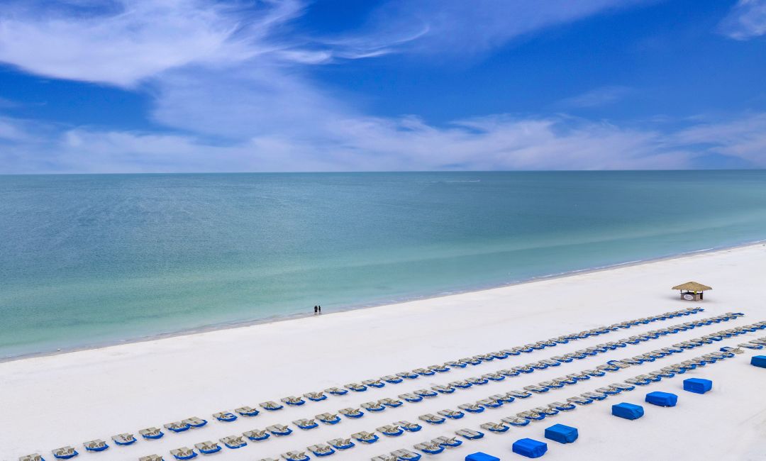 A Large Body Of Water With A Beach And Land Around It