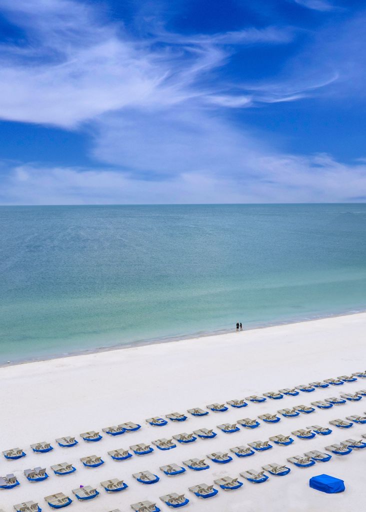 A Large Body Of Water With A Beach And Land Around It