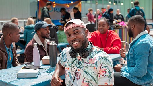Man sitting outside with surrounded by friends