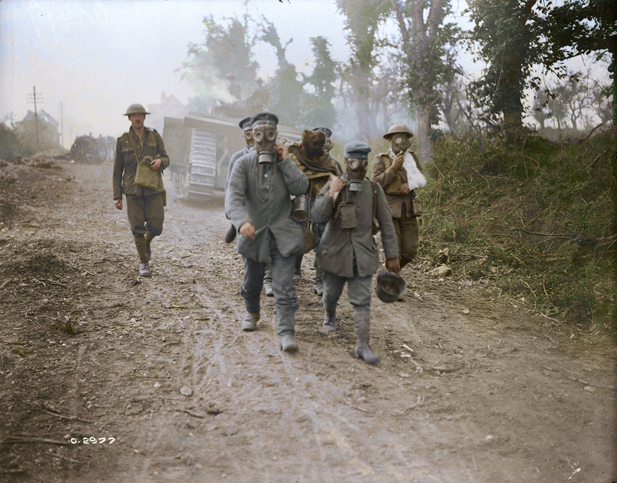 (Battle of Amiens) Tanks advancing. Prisoners bring in wounded wearing gas masks. Aug 1918.