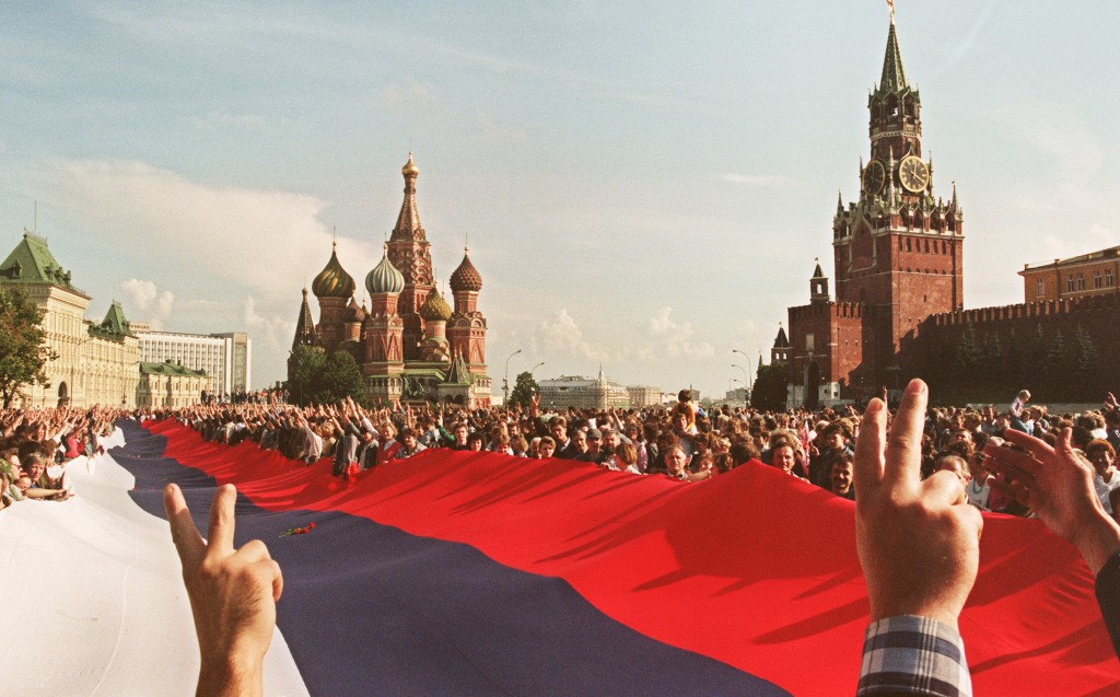 People holding a huge Russian flag flash victory signs on Aug. 22, 1991, on Red Square in Moscow as they celebrate the failure of a hardline communist-led coup which nearly toppled Mikhail Gorbachev. Photo by Anatoly Sapronyenko/AFP/Getty Images