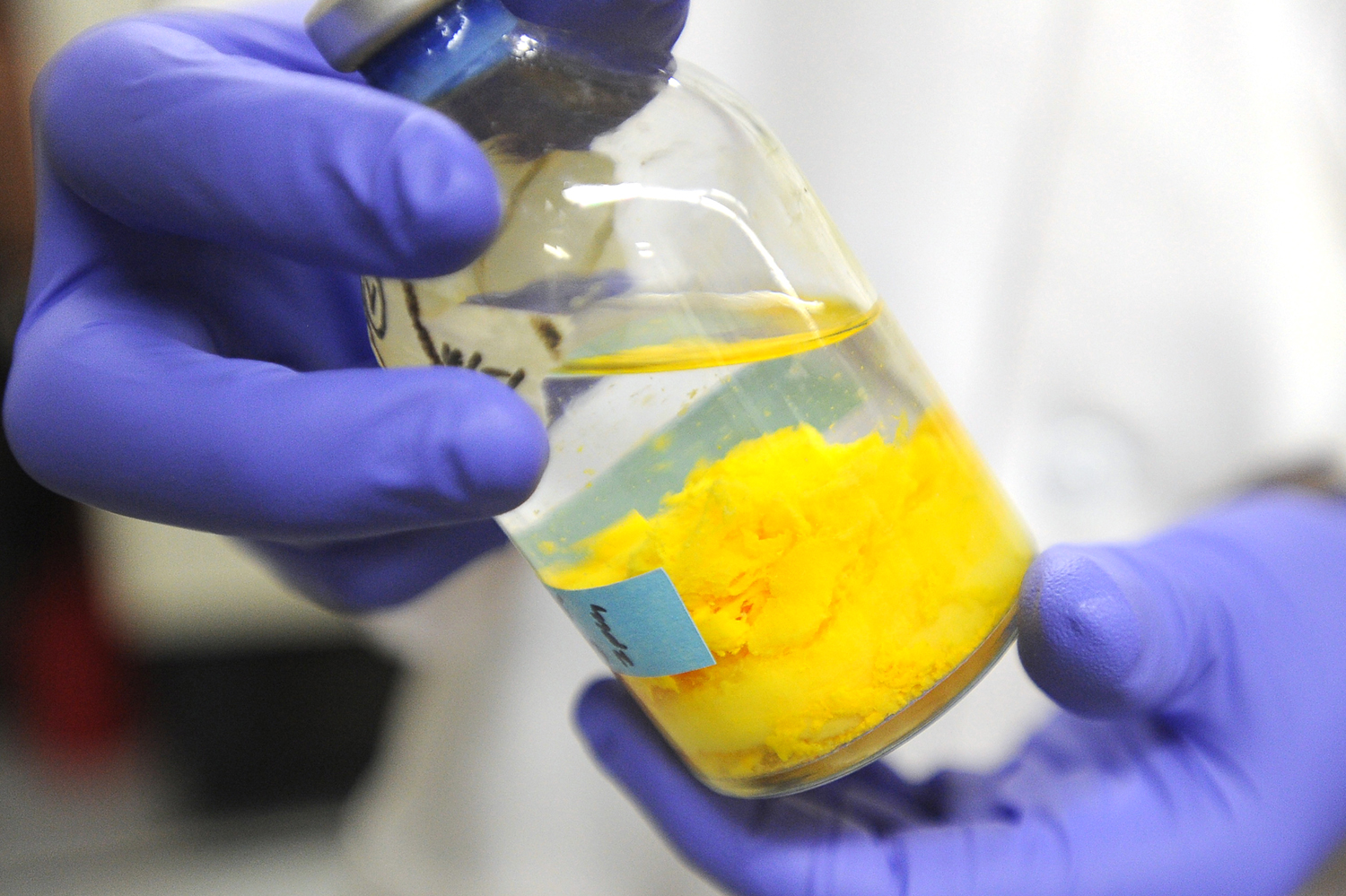 Graduate student Ian McFarlane holds a bottle containing anaerobic bacteria cells used in the study of biological electron transport. Scientists at the University of Southern California are doing basic research to determine how certain bacteria are able to transfer electrons great distances from themselves to other cells or inorganic minerals. Photograph by Kent Treptow for PBSNewsHour