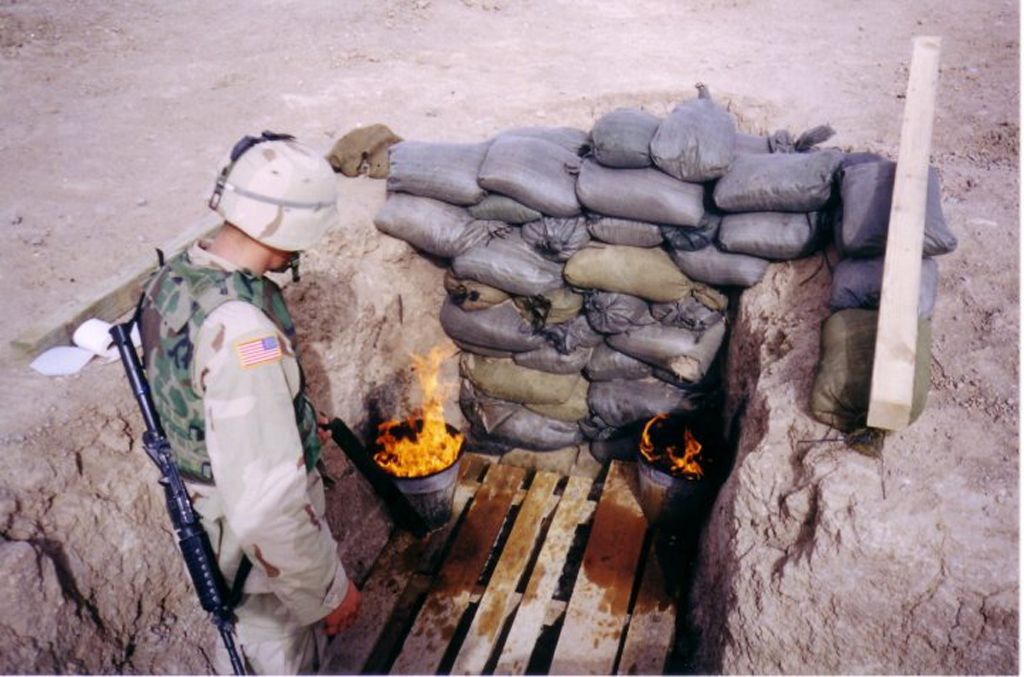 Burning open pit toilets in Kandahar, Afghanistan in 2002. Photo by Timothy Aponte.