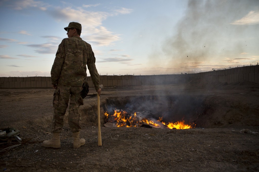 A U.S. Army soldier watches bottled water burn at Forward Operating Base Azzizulah in Maiwand District, Kandahar Province, Afghanistan, on Feb. 4, 2013. Photo by Andrew Burton/Reuters