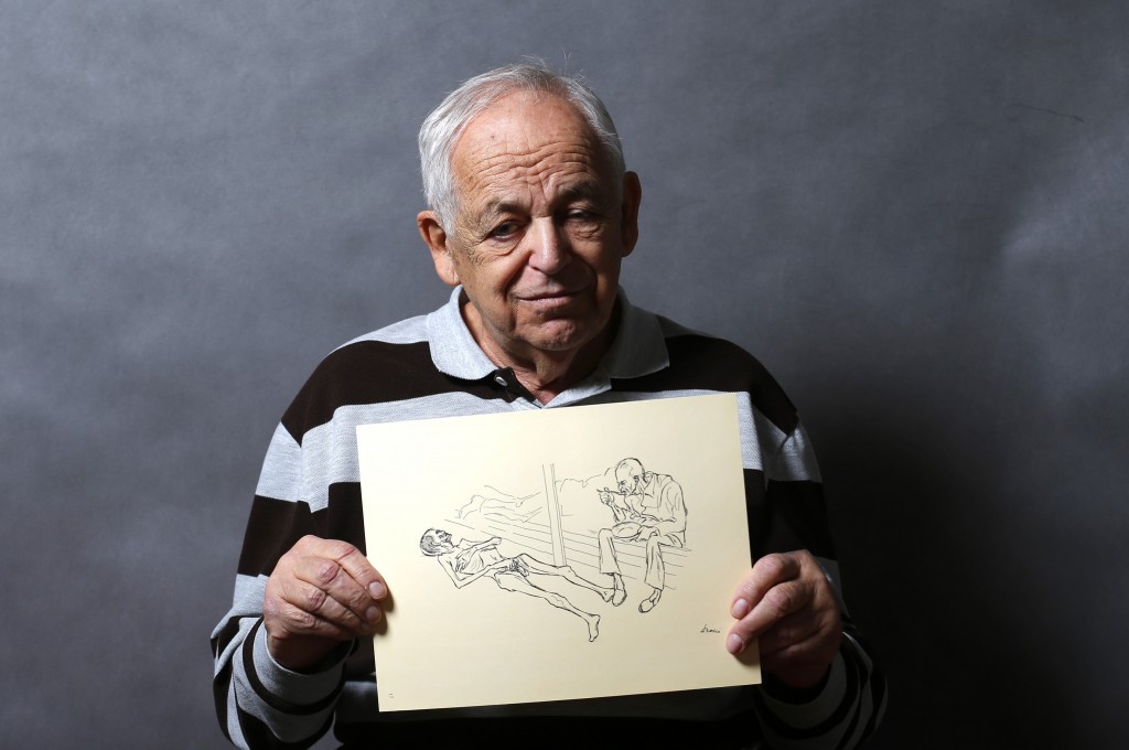 Auschwitz death camp survivor Lajos Erdelyi holds a drawing made by a campmate as he poses for a portrait in Budapest