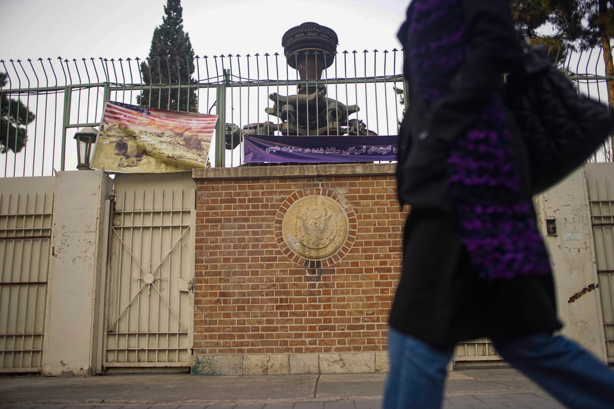 Entry gate of the former U.S. embassy in Tehran. The banner hanging upper left is allegedly a photo of the wreckage of the failed American rescue mission from 1980, where eight U.S. military members died when their aircraft were damaged in a sand and dust storm and crashed. The Iranians claim the machine parts up behind the gate are from one of those U.S. aircraft.