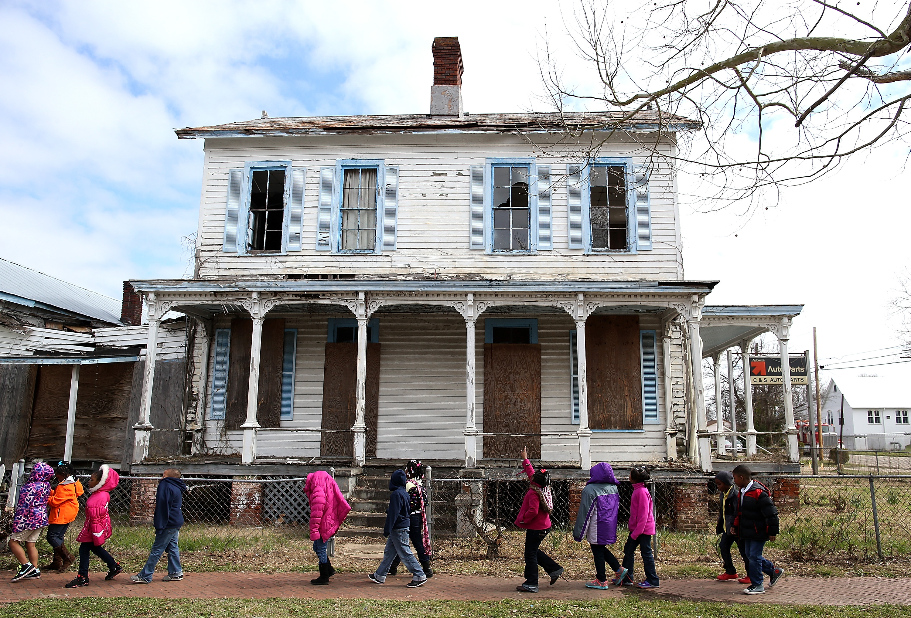 SELMA, AL - MARCH 06: School kids walk by a vacant home that is along the historic route that civil rights marchers took during the Selma to Montgomery march on March 6, 2015 in Selma, Alabama. 50 years after the historic civil rights march from Selma to Montgomery where marchers were beaten by State police officers as they crossed the Edmund Pettus Bridge, Selma struggles economically and is one of the poorest cities in Alabama with a 10.2 percent unemployment rate and over 40 percent of residents living below the national poverty level. (Photo by Justin Sullivan/Getty Images)