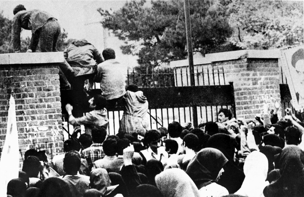 Iranian students climb over the wall of the U.S. embassy in Tehran during the Iranian Revolution, Nov. 4, 1979. The students went on to seize the embassy staff, and hold 52 of them hostage for 444 days. Photo by AFP/Getty Images