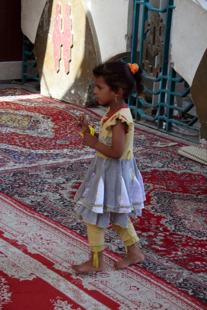 Prayer Rugs A girl waits for her mother to stow their shoes before entering the mosque. Ten percent, or more than 100 million, of the world’s Muslims are Shiite. Photo by Larisa Epatko