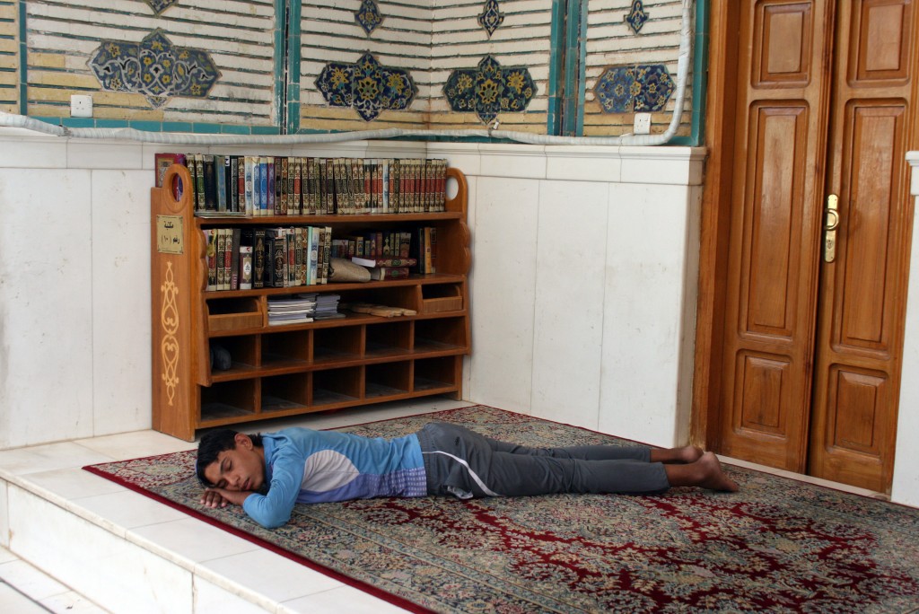 Prayer and Sleep A boy slumbers in a side prayer room during the hot summer day. Photo by Larisa Epatko