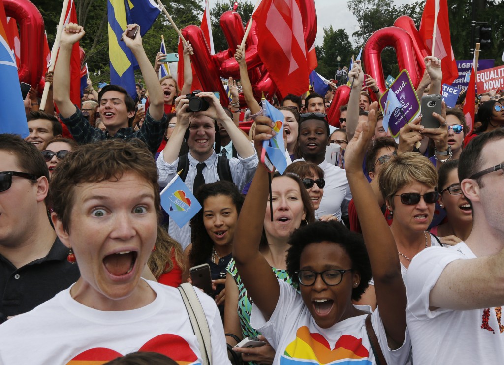 Gay rights supporters celebrate after the U.S. Supreme Court ruled that the U.S. Constitution provides same-sex couples the right to marry, outside the Supreme Court building in Washington, June 26, 2015. REUTERS/Jim Bourg - RTX1HXN9