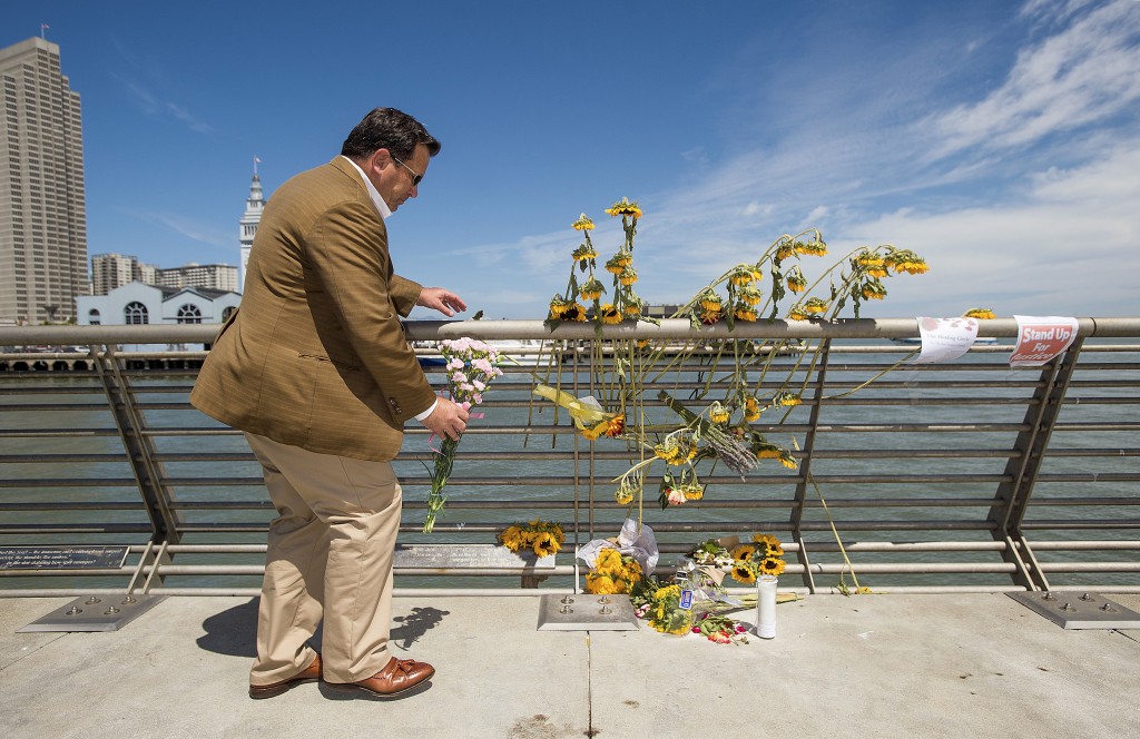 Steve, who declined to give a last name, leaves flowers at a makeshift memorial for shooting victim Kathryn Steinle on Pier 14 in San Francisco, California July 6, 2015. Steinle, 32, was fatally shot as she walked with her father along the popular Embarcadero pier on July 1, 2015 in what San Francisco police described as an apparent random attack. The random fatal shooting, allegedly by an immigrant, proves the United States must tighten its borders, according to a statement on Friday by U.S. presidential candidate Donald Trump, who is facing heavy criticism for his comments about Mexicans. REUTERS/Noah Berger