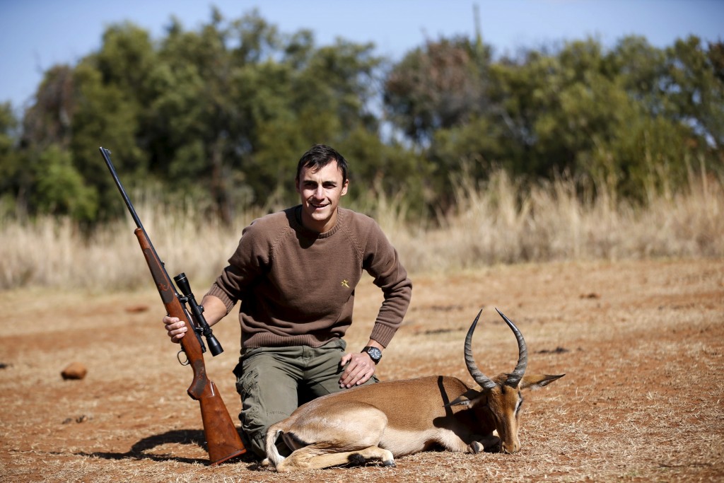 Francois Cloete poses in front of an Impala that he shot at the Iwamanzi Game Reserve in the North West Province, June 6, 2015. Africa's big game hunting industry helps protect endangered species, according to its advocates. Opponents say it threatens wildlife. Now a mooted change in regulations in the United States could affect the number of foreigners who come to Africa to hunt big game, damaging the industry and possibly hurting wildlife. Picture taken June 6, 2015. REUTERS/Siphiwe Sibeko - RTX1G43K