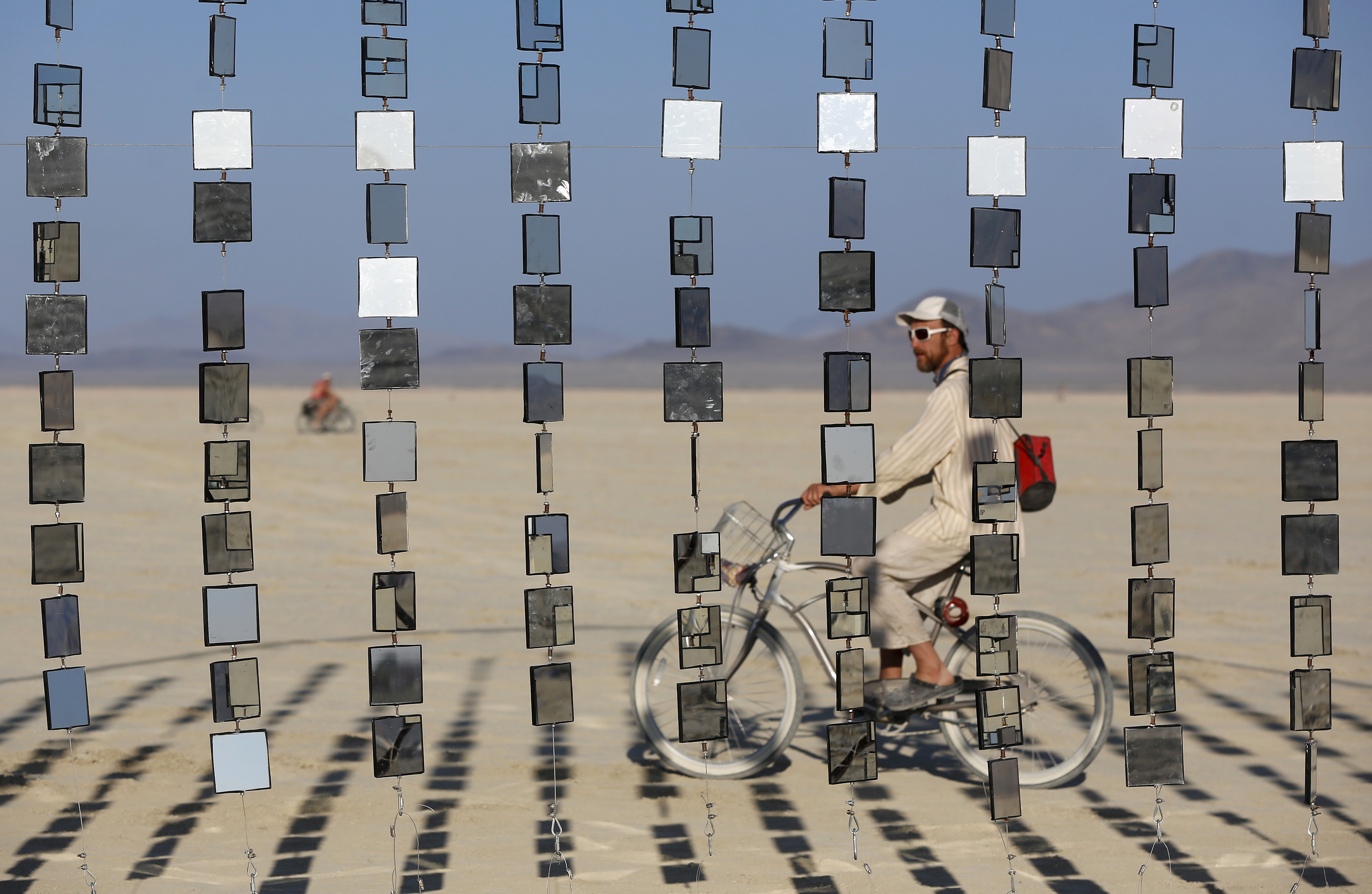 A man rides by an art installation at the Burning Man 2015 "Carnival of Mirrors" festival on Aug. 31. The event’s first legal permit came from the Bureau of Land Management in 1991. Photo by Jim Urquhart/Reuters