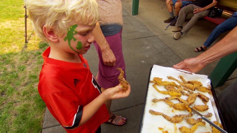 A child tries some Cajun-fried bullfrog legs. Photo by Nick Fisher/OPB