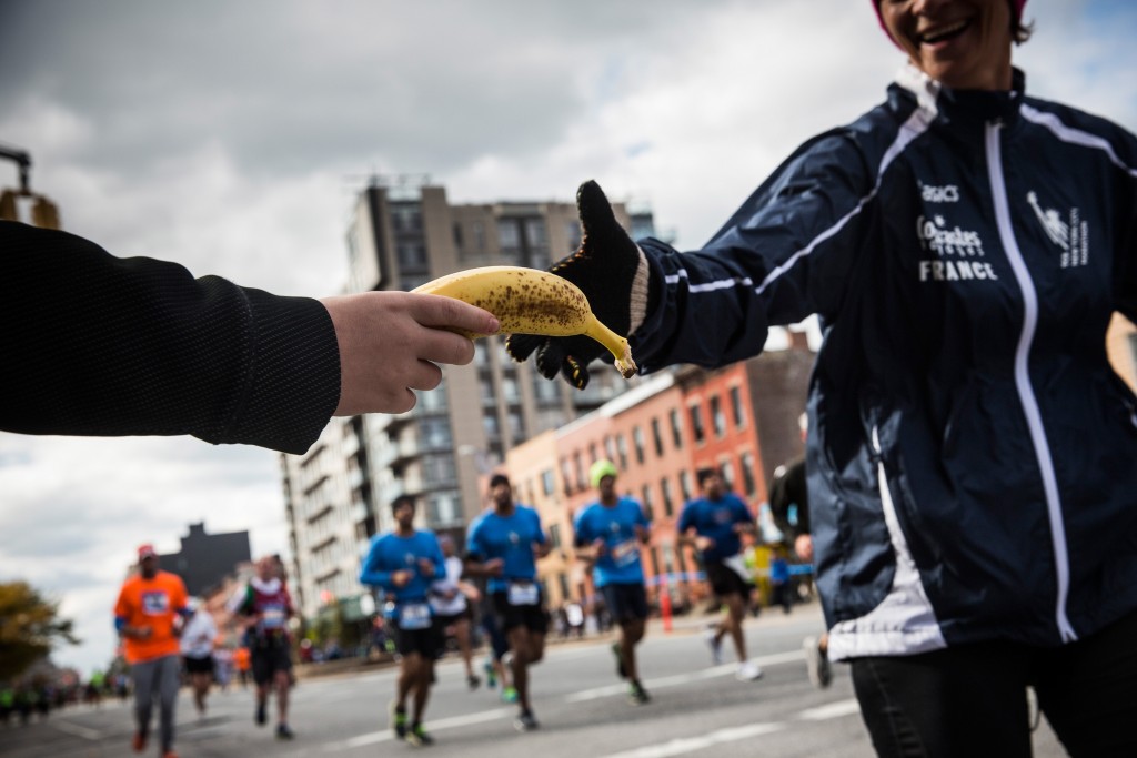 A volunteer hands out bananas to runners participating in the TCS New York City Marathon on November 2, 2014. Photo by Andrew Burton/Getty Images.