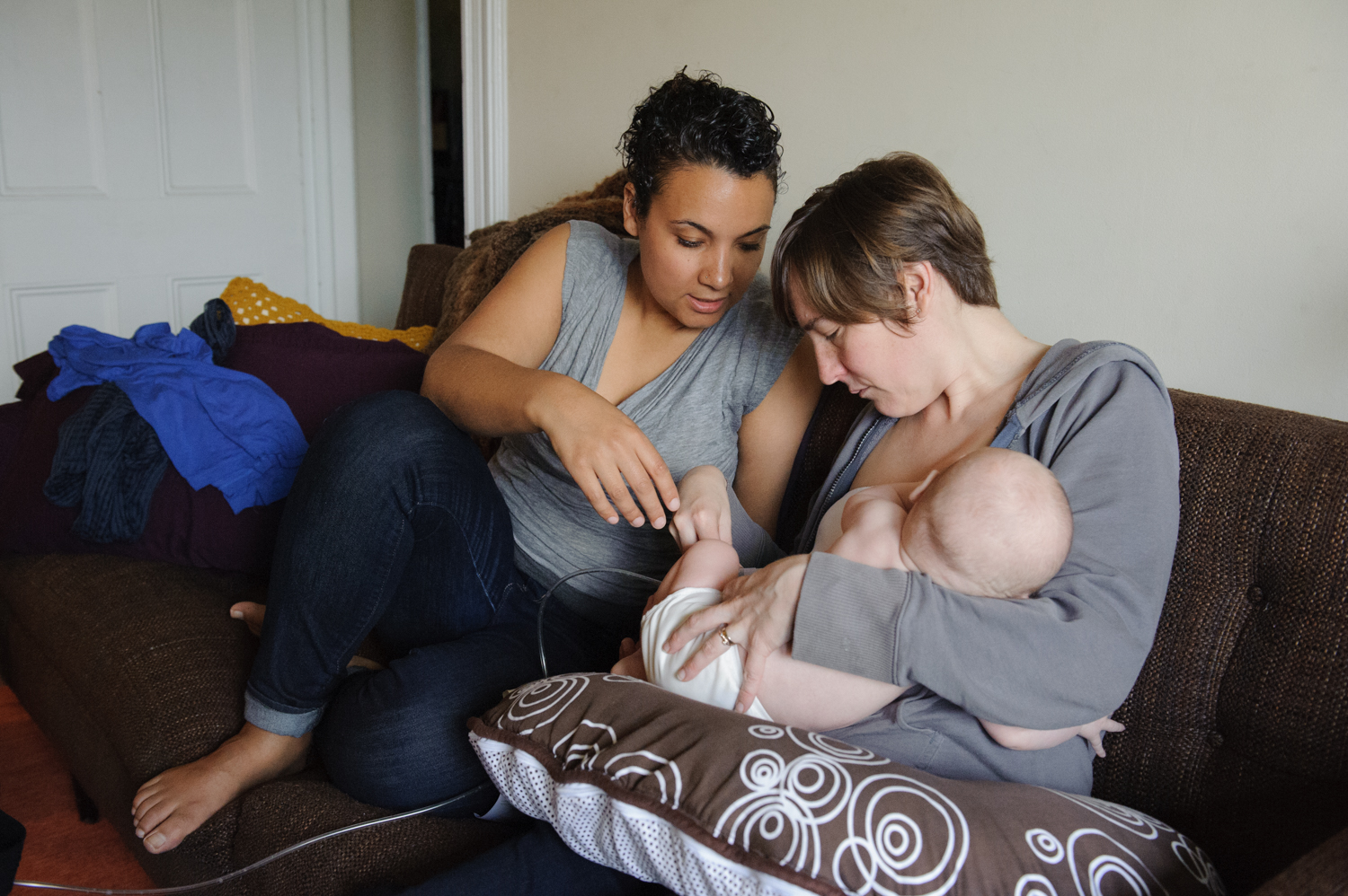 Kamdyn Moore and her wife Tomara Aldrich check to make sure the breast pump is working as Tomara nurses their four-month-old son, Spencer, and pumps simultaneously before work.