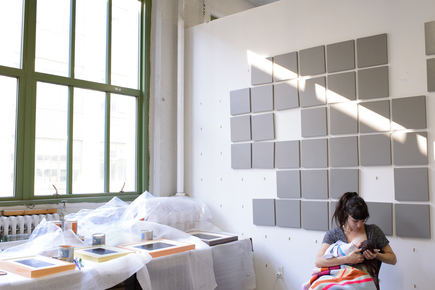 Painter Marcie Paper breastfeeds her ten-day-old baby, Andi Paige, in the studio where Paper works for a conceptual artist, managing his studio and producing his paintings.