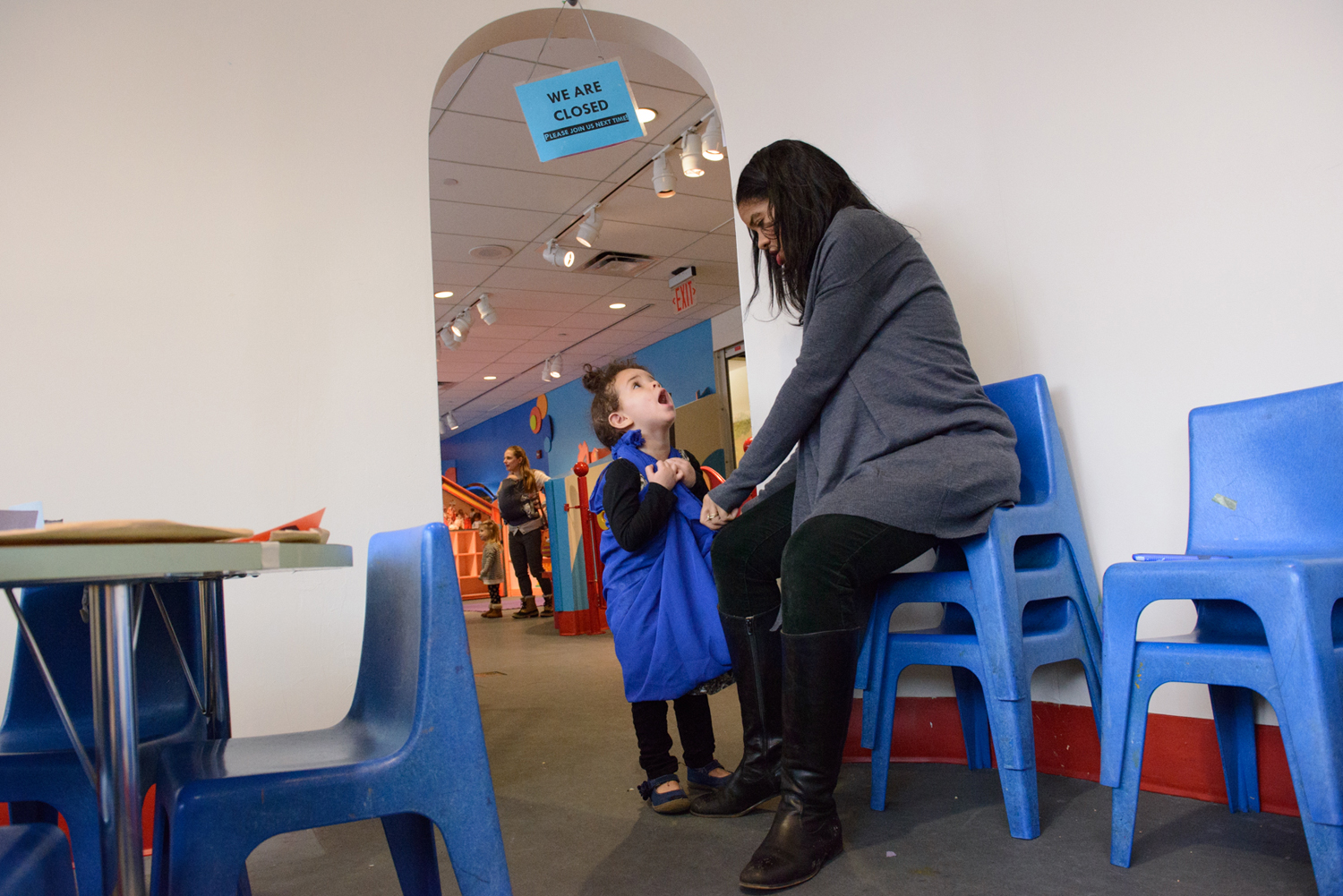 Seven months pregnant, Vice President of Programs and Education at Brooklyn Children's Museum Petrushka Bazin Larsen fixes her daughter, Ila Bazin Larsen's "Elsa dress" while working on a stressful day when child care had fallen through.