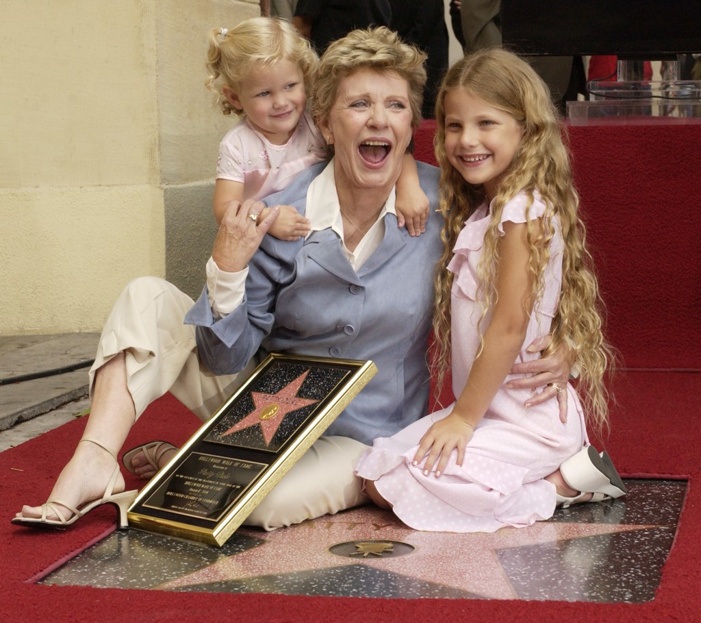 Award-winning actress Patty Duke poses for photographers with her granddaughters, 2-year-old Elizabeth Astin (left) and 7-year-old Alexandra Astin following an unveiling ceremony, honoring Duke with the 2,260th star on the Hollywood Walk of Fame in Los Angeles, California on Aug. 17, 2004. Duke won the Oscar for best supporting actress for "The Miracle Worker" at 16, the youngest at the time to be so named. Photo by Jim Ruymen/Reuters