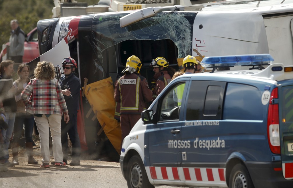 Firemen stands next to the wreckage of a bus after a traffic accident in Freginals, Spain, March 20, 2016. REUTERS/Albert Gea - RTSBB86