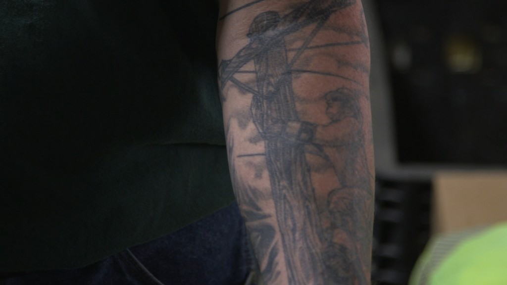 Kevin Hinrichs shows off his lineman tattoo. Hinrichs has worked as a lineman for Xcel Energy for 25 years. Photo by Brian Malone/Inside Energy