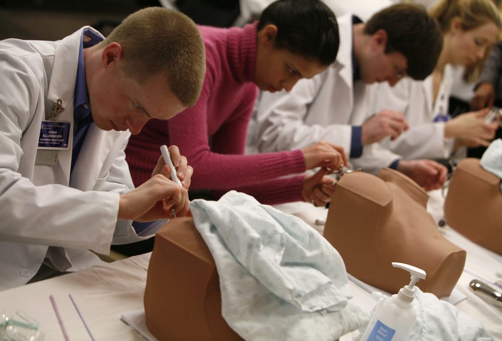 First year Northwestern University medical students perform a pelvic exam on rubber dummies during their human anatomy class in Chicago, Illinois March 15, 2007. Photo by Joshua Lott/ REUTERS