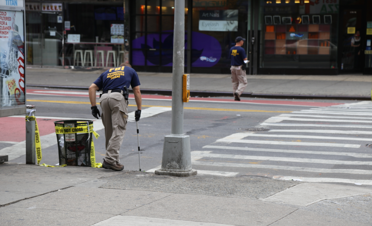 FBI investigators search an area near the scene of a bomb placed in a garbage Dumpster Saturday night. Authorities said the blast does not appear to have links to a global terrorism network. Photo By Michael D. Regan/PBS NewsHour