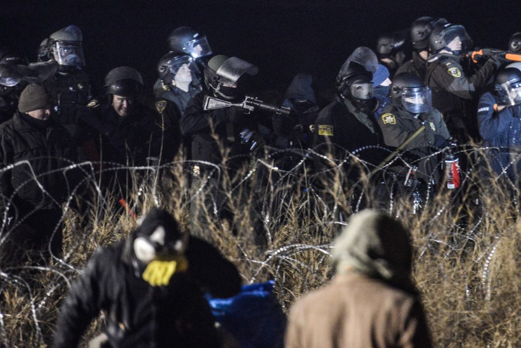 Police confront protesters with a rubber bullet gun during a protest against plans to pass the Dakota Access pipeline near the Standing Rock Indian Reservation, near Cannon Ball, North Dakota. Photo by Stephanie Keith/Reuters
