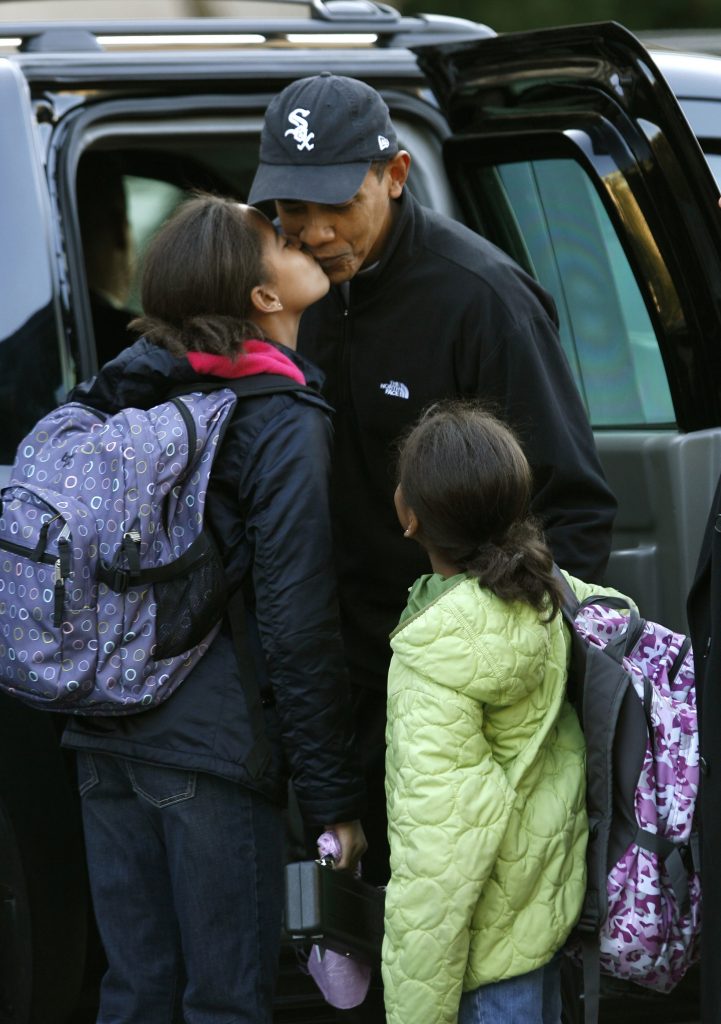 U.S. President-elect Barack Obama gets a kiss from his daughter Malia as his younger daughter Sasha watches upon being dropped off at their school in Chicago November 10, 2008. REUTERS/Kevin Lamarque (UNITED STATES) - RTXAGEA
