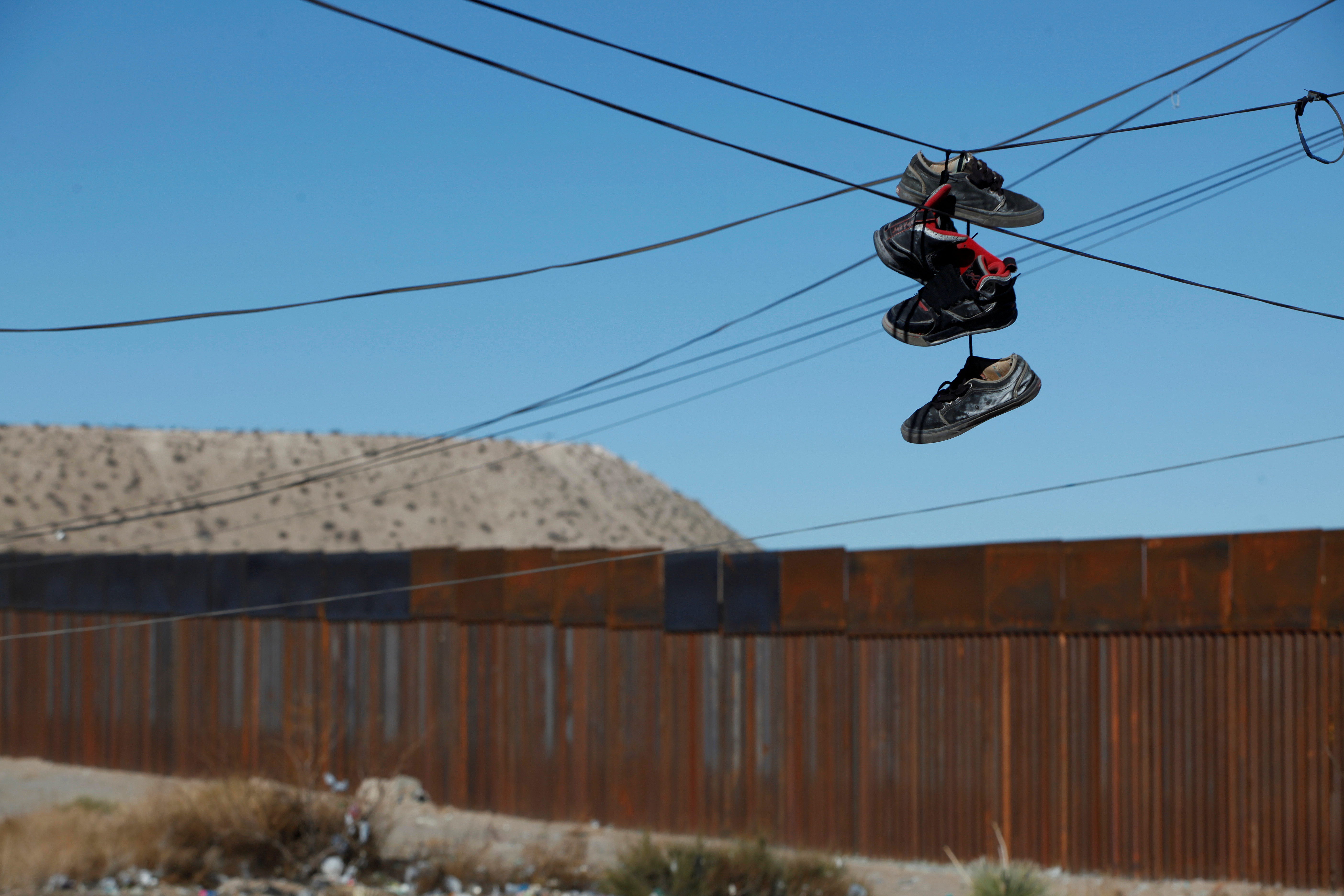 Shoes hang from a power line near the border fence in the Anapra neighborhood of Ciudad Juarez, Mexico. Photo by Jose Luis Gonzalez/Reuters