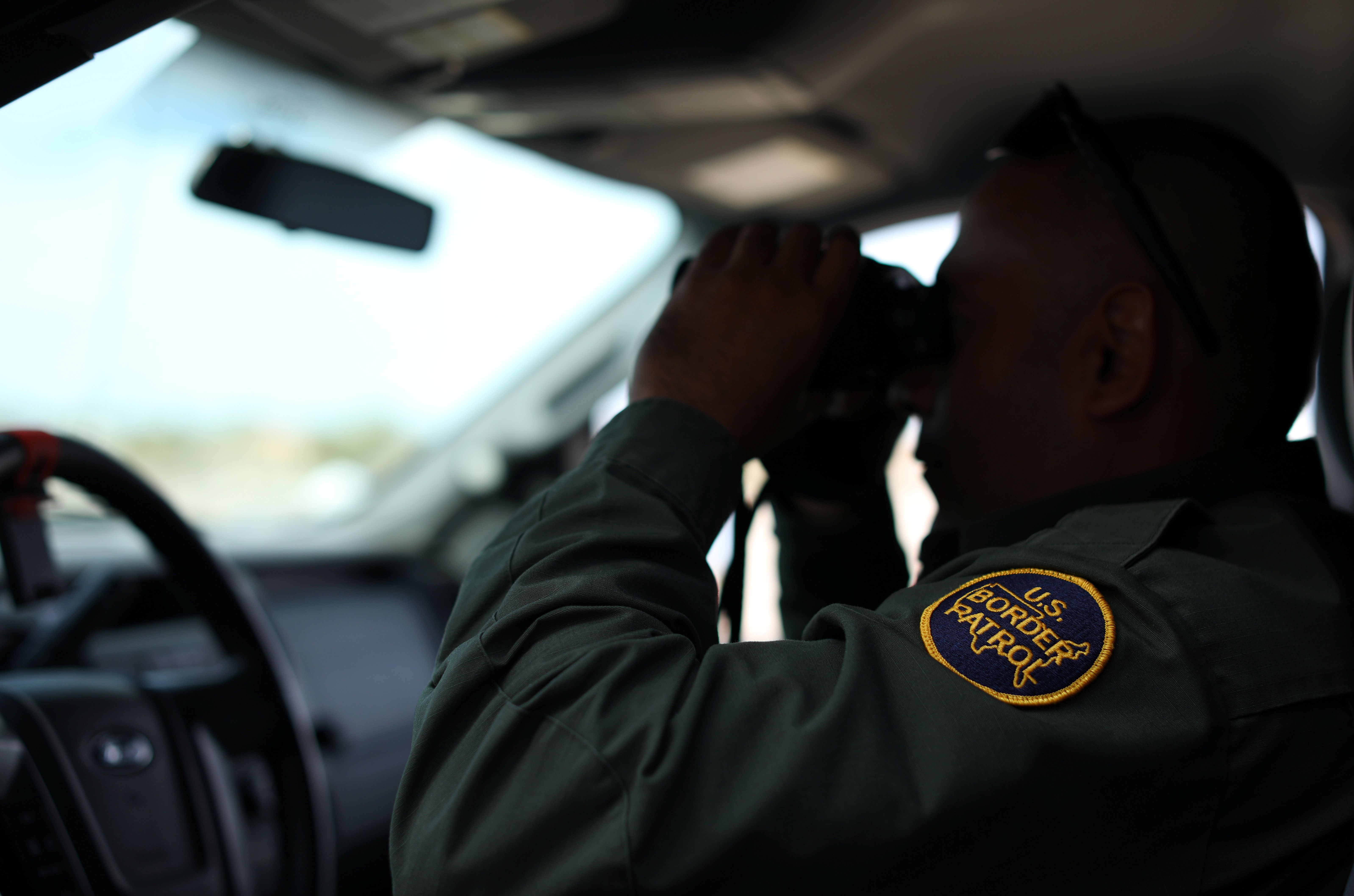 A U.S. border patrol agent keeps watch along the fence next to the Mexican border in Calexico, California. Photo by Mike Blake/Reuters