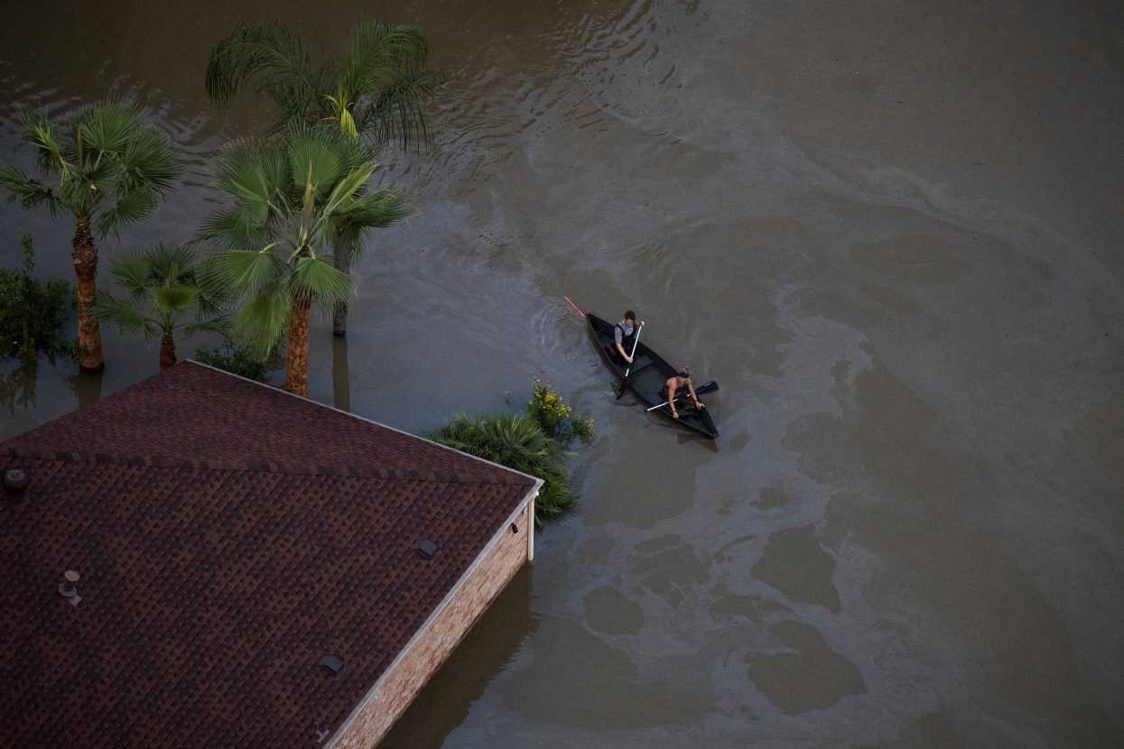 Residents use a canoe to navigate through flood waters brought by Tropical Storm Harvey in Northwest Houston