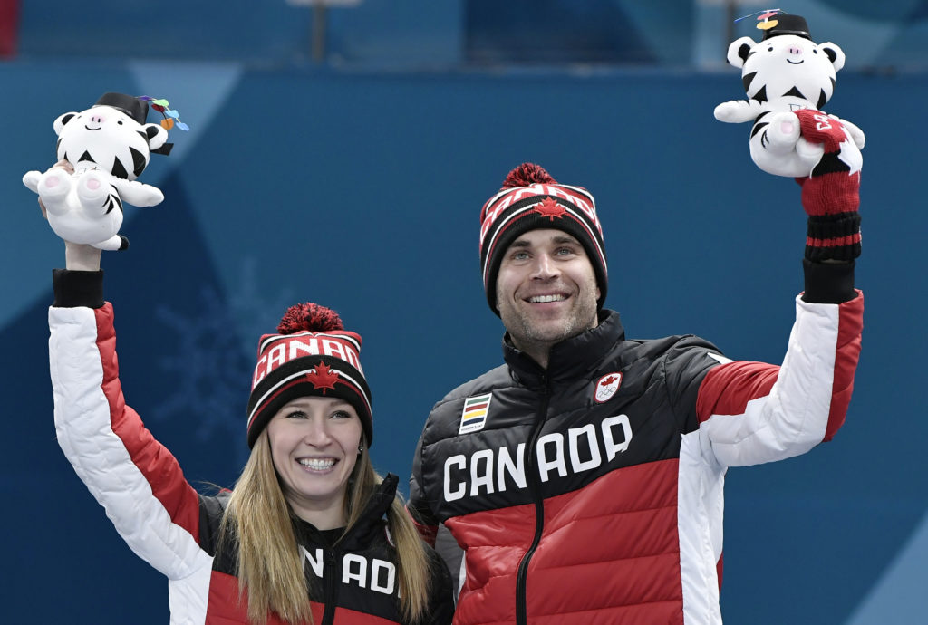 Gold medalists Kaitlyn Lawes and John Morris of Canada celebrate during the victory ceremony at the 2018 Winter Games. Photo by Toby Melville/Reuters