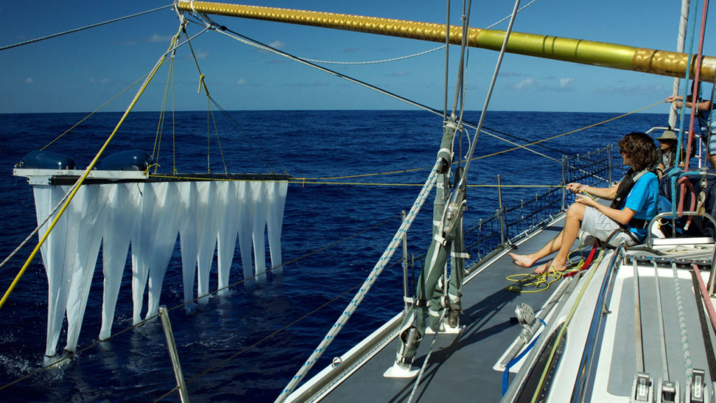 A scientist lowers a multi-level-trawl into the ocean. Photo by The Ocean Cleanup