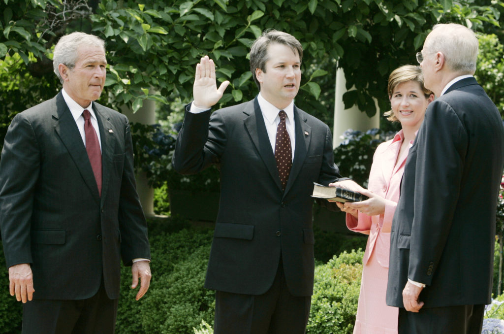 U.S. President George W. Bush (L) watches as Brett Kavanaugh (2nd L) is sworn in as a judge in the U.S. Court of Appeals for the District of Columbia by Supreme Court Associate Justice Anthony Kennedy (R) in a Rose Garden ceremony at the White House in Washington June 1, 2006. Kavanaugh's wife, Ashley, holds the bible. REUTERS/Larry Downing (UNITED STATES) - GM1DSSTWUSAA