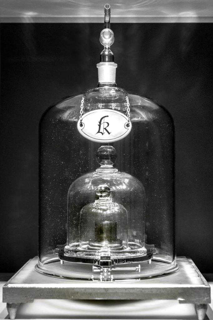 The International Prototype of the Kilogram, also known as Le Grand K, was the internationally sanctioned artifact that defined the amount of weight equivalent to one kilogram. It is kept under three glass domes in a vault for protection. Image courtesy of BIPM.