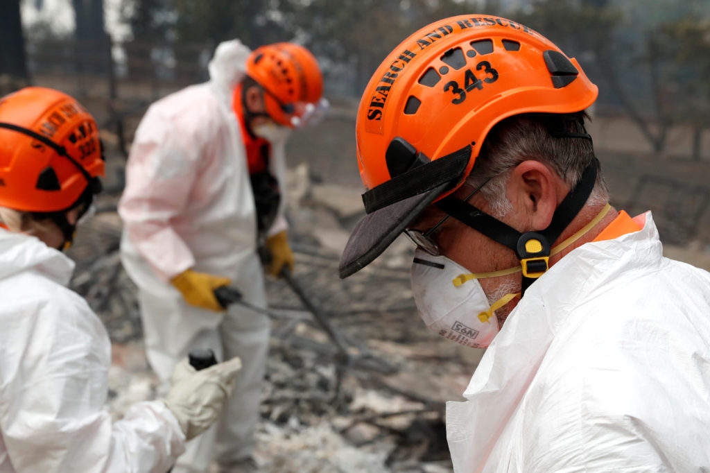 A volunteer search and rescue crew from Calaveras County comb through a home destroyed by the Camp Fire in Paradise, California. Photo by Terray Sylvester/Reuters