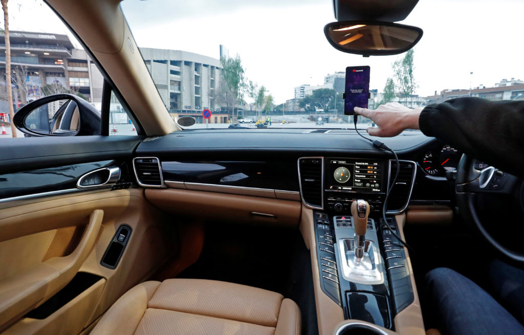 An engineer points to a Huawei Mate 10 Pro mobile used to control a driverless car during the Mobile World Congress in Barcelona, Spain. Photo by Yves Herman/Reuters