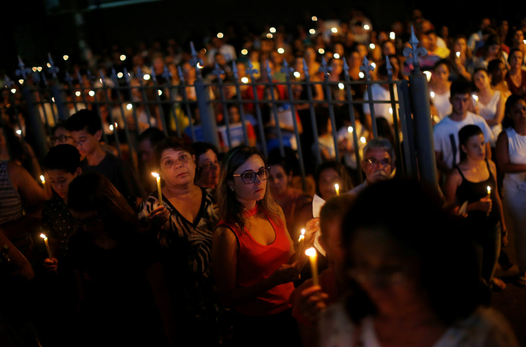 Relative and friends of victims of a collapsed tailings dam owned by Brazilian mining company Vale SA, carry candles as they pay respects during a vigil in Brumadinho, Brazil January 31, 2019. Photo by Adriano Machado/Reuters