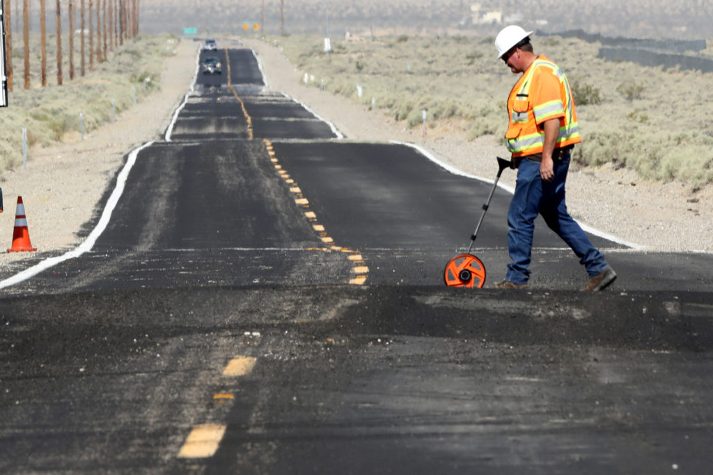 A worker takes measurements at a site where Highway 178 is distorted over newly ruptured ground after an earthquake broke, triggered by a previous day quake, in Southern California, east of the city of Ridgecrest, California, U.S., July 6, 2019. Photo by REUTERS/David McNew