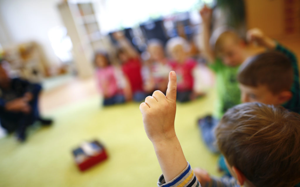 Children gesture as they sit in a playing circle at their kindergarten run by a private foundation which is not affected by the nursery caretakers strike in Hanau, 30km south of Frankfurt, Germany, May 8, 2015. Most of the kindergartens run by public services all over Germany face a strike of the nursery caretakers as they fight for higher wages and better working conditions. 