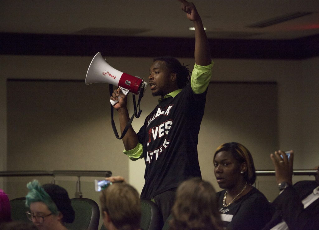 Muhiydin Moye D'Baha of the Black Lives Matter movement, uses a bull horn to make a point during a news conference with North Charleston Police and Government officials in North Charleston, South Carolina April 8, 2015. Demonstrators rallied on Wednesday against what they described as a culture of police brutality in South Carolina in the case of white officer Michael Slager, who was caught on video killing 50-year-old Walter Scott, a black man, by shooting him in the back as Scott ran away after a traffic stop. Slager was charged on Tuesday with murder in the death of Scott. Photo by Randall Hill/Reuters