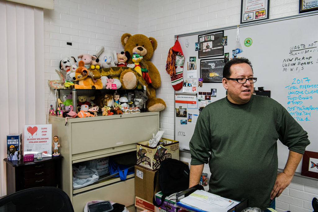 Joseph Gaxiola, who has lived with HIV for 21 years, in his office at the Joshua Tree Feeding Program — a food pantry for the HIV positive community in Phoenix — where he volunteers as chairman. Photo Credit: Ash Ponders