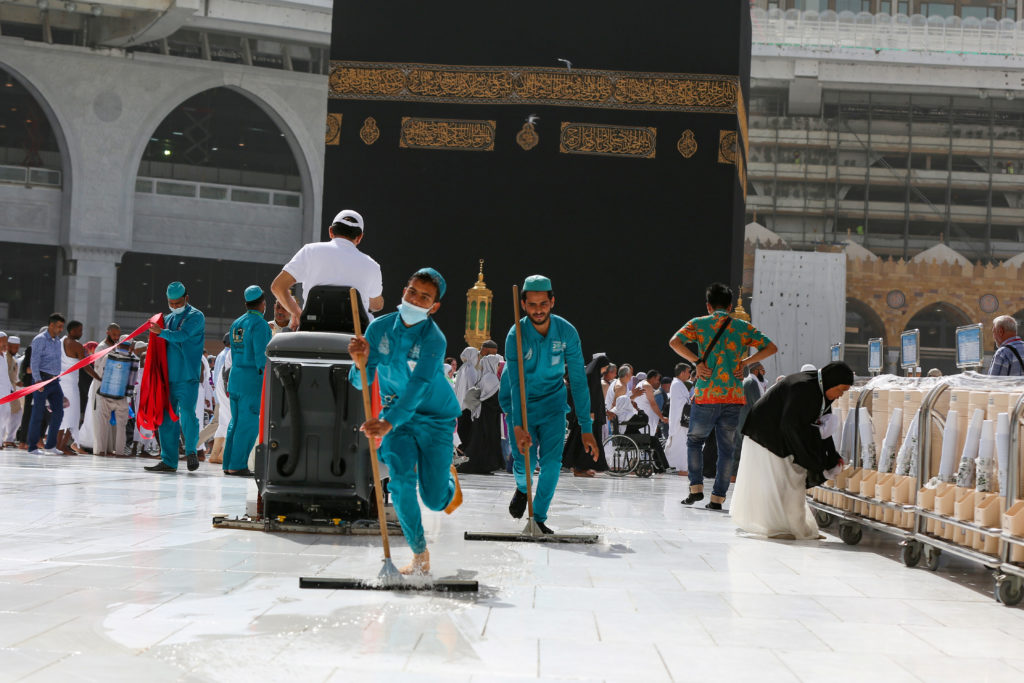 Cleaners wear protective face masks, following the outbreak of the coronavirus, as they swipe the floor at the Kaaba in the Grand mosque in the holy city of Mecca, Saudi Arabia. Photo by Ganoo Essa/Reuters