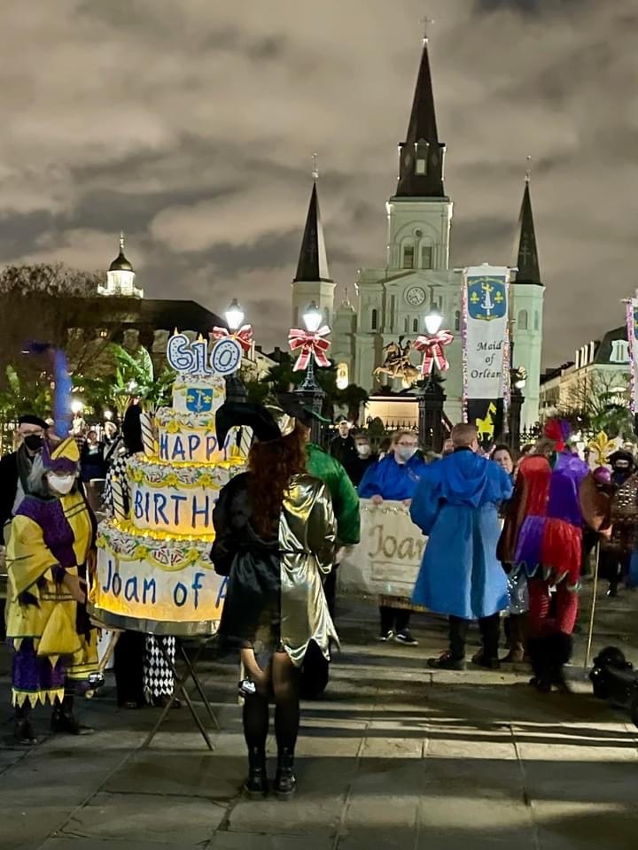 Members of the Joan of Arc parade march through the streets of New Orleans near Jackson Square.