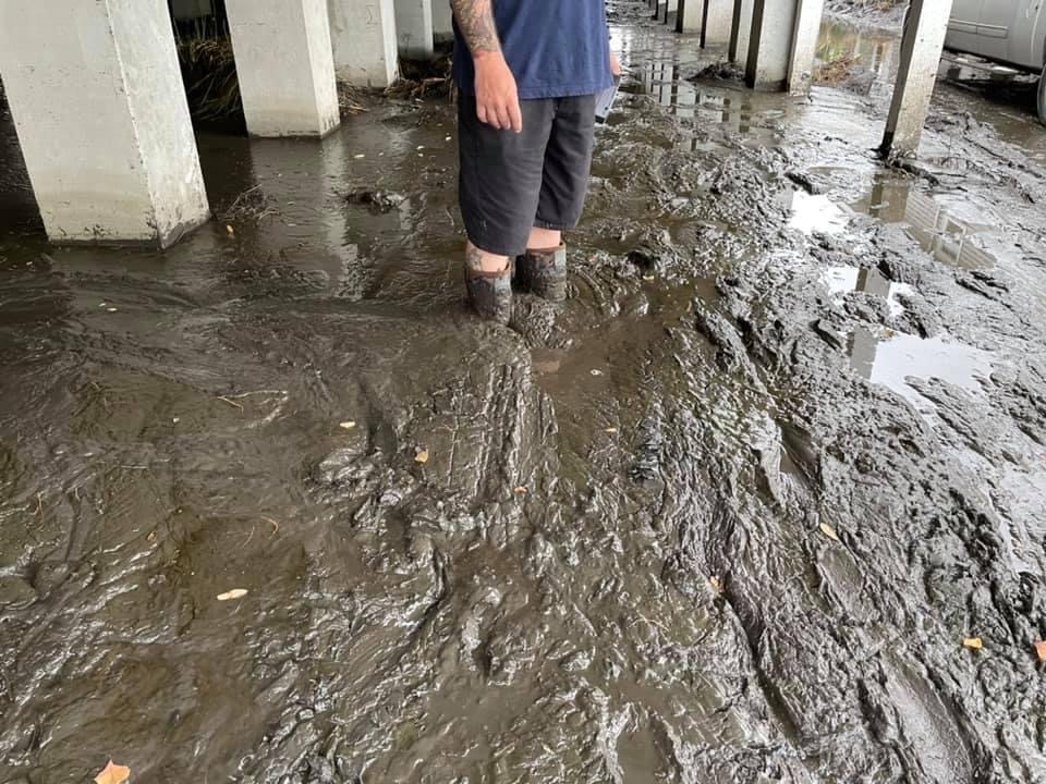 Man walks through mud following Hurricane Ida.