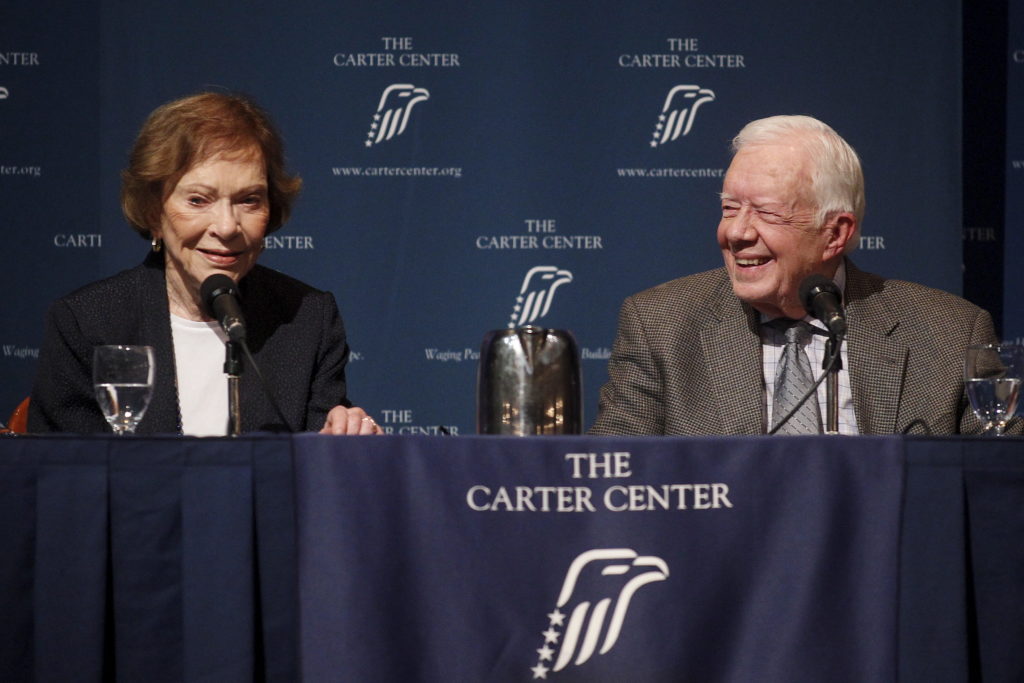 Former U.S. President Jimmy Carter laughs as wife Rosalynn Carter speaks during "A Conversation with the Carters," an annu...