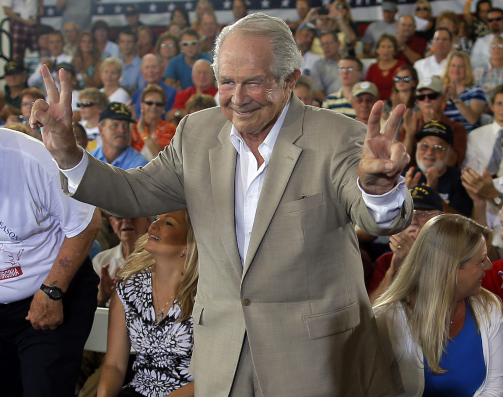 Evangelical Christian leader Pat Robertson takes his seat onstage ahead of a campaign rally with Republican presidential c...
